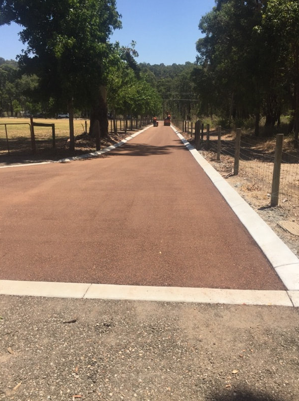 This is a photo of a hot spray & seal bitumen roadway which is in the process of being installed by Mulgrave Surfacing Solutions